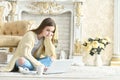 Beautiful teen girl sitting on floor and using laptop Royalty Free Stock Photo