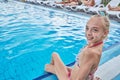 A teenage girl is sitting sitting by the pool Royalty Free Stock Photo