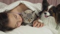 Beautiful teen girl sleeping sweetly in bed with dog and cat Royalty Free Stock Photo