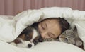 Beautiful teen girl sleeping sweetly in bed with dog and cat Royalty Free Stock Photo