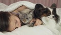 Beautiful teen girl sleeping sweetly in bed with dog and cat Royalty Free Stock Photo