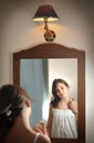 A beautiful teen girl studies her appearance as she looks into the mirror Royalty Free Stock Photo