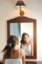 A beautiful teen girl studies her appearance as she looks into the mirror Royalty Free Stock Photo