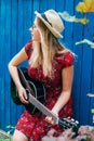 Beautiful teenage blonde long haired girl playing acoustic guitar outdoor. Vertical image Royalty Free Stock Photo