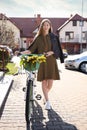 Beautiful teenage girl with bicycle and bouquet of yellow tulips outdoors on sunny day Royalty Free Stock Photo