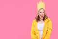 Beautiful teenage girl in bright yellow jacket and party hat shouting with excitement. Attractive cool woman fashion portrait. Royalty Free Stock Photo