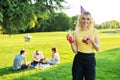 Beautiful teenage girl in a festiv hat on her birthday with a cake and candles.