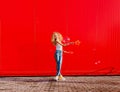 Beautiful teenage girl inflates soap bubbles against the red wall Royalty Free Stock Photo