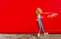 Beautiful teenage girl inflates soap bubbles against the red wall Royalty Free Stock Photo