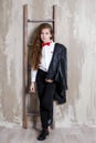 Studio portrait of a girl in a white shirt with a bow tie on a gray background Royalty Free Stock Photo