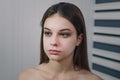 Beautiful teenage girl model getting professional make-up. Beauty portrait of female teenager in process of visage. Cosmetics