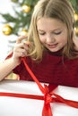 Beautiful teenage girl opening her christmas prese Royalty Free Stock Photo