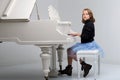 Beautiful teenage girl playing grand piano. Photo session in the studio Royalty Free Stock Photo