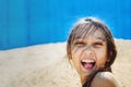 Beautiful teenage girl in the sand with wet dark hair laughing loudly on the beach in a summer sunny day Royalty Free Stock Photo