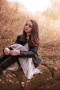 Beautiful teenage girl sitting on a stone wall Royalty Free Stock Photo