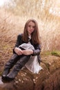 Beautiful teenage girl sitting on a stone wall Royalty Free Stock Photo