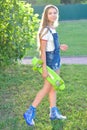 Beautiful teenage girl with skateboard in the green park in summer Royalty Free Stock Photo