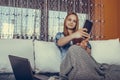 Beautiful teenage girl using laptop and taking selfie with her mobile phone, at home Royalty Free Stock Photo