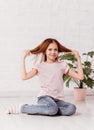 Beautiful teenage girl in the white room smiling and playing with hair Royalty Free Stock Photo