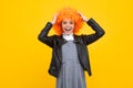 Beautiful teenage girl in wig isolated on yellow. Funny clown wig. Excited face, cheerful emotions of teenager girl. Royalty Free Stock Photo