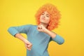 Beautiful teenage girl in wig isolated on yellow. Funny clown wig. Excited teenager, glad amazed and overjoyed emotions. Royalty Free Stock Photo