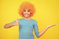 Beautiful teenage girl in wig  on yellow. Funny clown wig. Happy teenager portrait. Smiling girl. Royalty Free Stock Photo