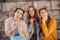 Beautiful teenage girlfriends in trendy dresses and glasses walk in the summer. Sunny day, summer mood, fun and happiness. Three Royalty Free Stock Photo