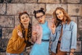 Beautiful teenage girlfriends in trendy dresses and glasses walk in the summer. Sunny day, summer mood, fun and happiness. Three Royalty Free Stock Photo