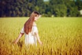 Beautiful Teenage Model girl Dressed in Casual Short Dress on the Field in Sun Light. Royalty Free Stock Photo