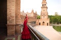 Beautiful teenage woman dancing flamenco in a square in Seville, Spain. She wears a red dress with ruffles and dances flamenco Royalty Free Stock Photo