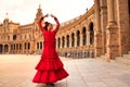 Beautiful teenage woman dancing flamenco in a square in Seville, Spain. She wears a red dress with ruffles and dances flamenco Royalty Free Stock Photo