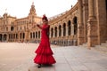 Beautiful teenage woman dancing flamenco in a square in Seville, Spain. She wears a red dress with ruffles and dances flamenco Royalty Free Stock Photo