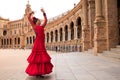 Beautiful teenage woman dancing flamenco in a square in Seville, Spain. She wears a red dress with ruffles and dances flamenco Royalty Free Stock Photo