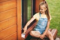 Beautiful teenager girl in denim overalls and a yellow T-shirt holds a brush in her hands and smiles. Happy family. Home Royalty Free Stock Photo