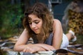 Beautiful teenager girl reading a book lying on blanket on green grass at the forest Royalty Free Stock Photo