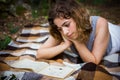 Beautiful teenager girl reading a book lying on blanket on green grass at the forest Royalty Free Stock Photo