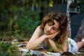 Beautiful teenager girl reading a book lying on blanket on green grass at the forest Royalty Free Stock Photo