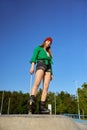 Beautiful teenager girl on roller skates posing for camera over blue sky Royalty Free Stock Photo