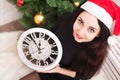 Beautiful teenager girl in Santa Claus clothes lying on the floor next to the Christmas tree and waiting a New Year. 5 more