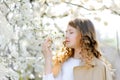 Beautiful teenager girl girl smelling flowers and enjoying warm sunny spring weather at countryside Royalty Free Stock Photo