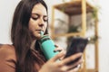 Teenager girl surfing social media on smart phone while having leisure time at her home