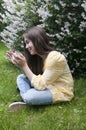 Beautiful teenager girl with tablet computer sits on the grass in Park. Photo Royalty Free Stock Photo