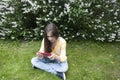 Beautiful teenager girl with tablet computer sits on the grass in Park. Photo Royalty Free Stock Photo