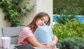 Beautiful teenager girl wrapped in warm knitted plaid daydreaming sitting outside Royalty Free Stock Photo