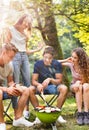 Teenagers camping, cooking vegetables on barbecue grill. Royalty Free Stock Photo