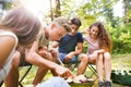 Teenagers camping, cooking vegetables on barbecue grill. Royalty Free Stock Photo