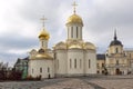 A beautiful temple with white walls and golden domes against a blue sky. Sergiev Posad, Russia, 11-18-2020 Royalty Free Stock Photo