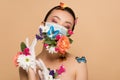 Beautiful tender asian girl with closed eyes in latex gloves and floral face mask with butterflies