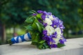 Beautiful tender wedding bouquet made of wite roses and blue flowers on concrete floor