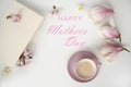 Beautiful tender flat still life, card on a beige background for mother`s day, magnolia buds, cup of cappuccino, concept of flora